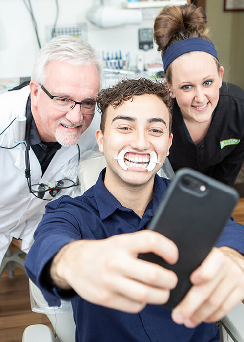 Dr. Kinney, a patient, and team member taking a selfie after a successful cosmetic dentistry visit
