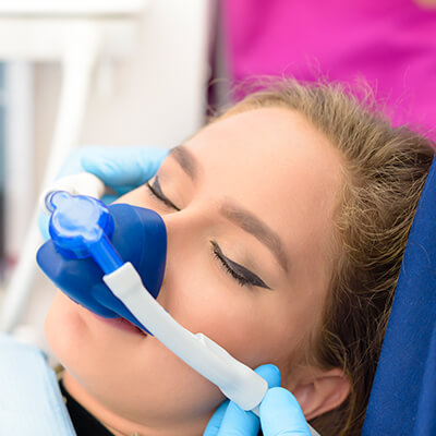 A woman looking relaxed while wearing a nasal hood as part of sedation dentistry