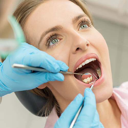 A woman being examined by a dentist by oral surgery
