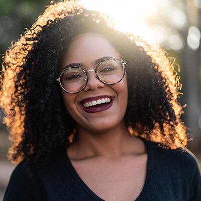 A woman smiling while wearing glasses