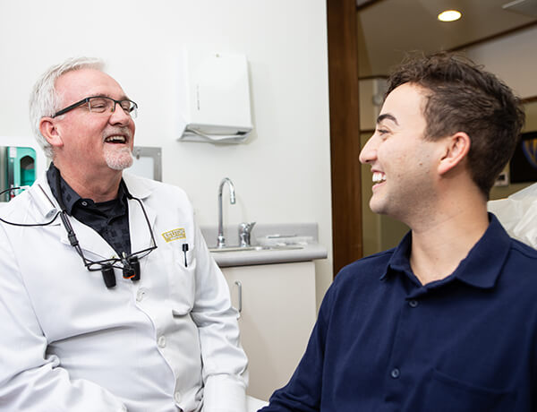 A male patient laughing with Dr. Kinney