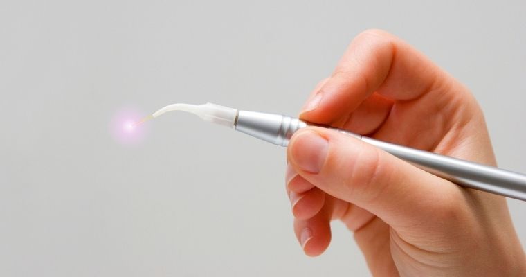 A hand holding a dental laser